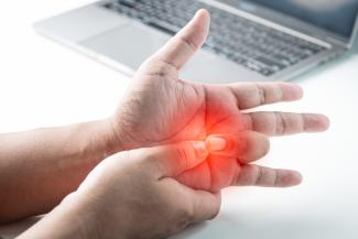 Person holding painful hand